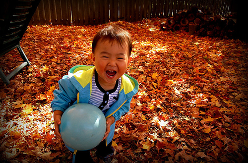 child in fall leaves