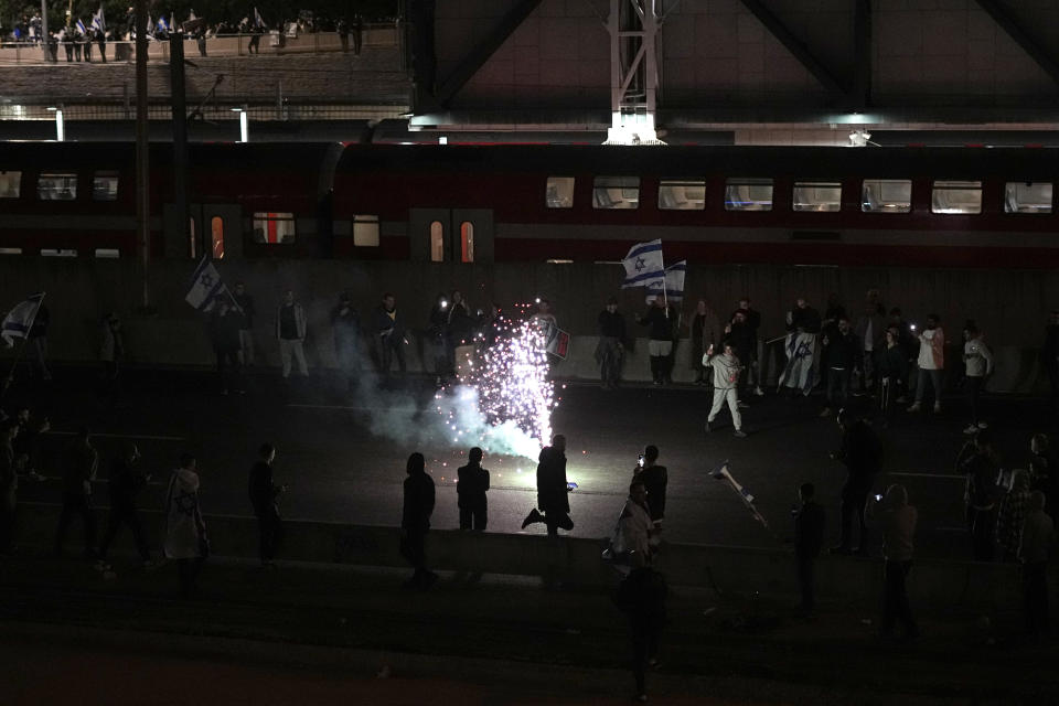 Right-wing Israelis block a main road as they rally in support of plans by Prime Minister Benjamin Netanyahu's government to overhaul the judicial system, in Tel Aviv, Israel, Thursday, March 30, 2023. (AP Photo/Ariel Schalit)