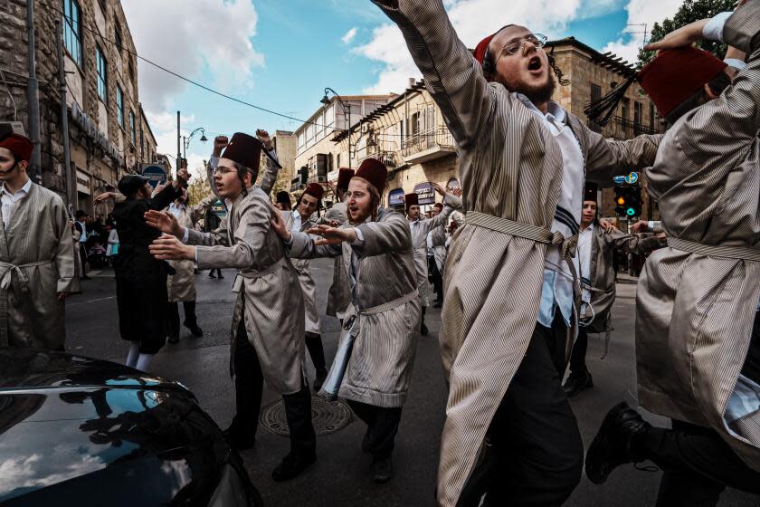 JERUSALEM, ISRAEL -- MARCH 25, 2024: Ultra orthodox men stop traffic as IsraelOs religious communities celebrate the Purim holiday by donning costumes, drinking alcohol, singing and dancing after traditional reading religious scriptures, in the Mea Shearim neighborhood Jerusalem, Israel, Monday, March 25, 2024. IsraelOs celebrations this year of the joyous holiday of Purim, based on a biblical account of Jewish salvation, presented a jarring juxtaposition with the war in Gaza, which has killed more than 32,000 Palestinians as Israel seeks to destroy the militant group Hamas. (MARCUS YAM / LOS ANGELES TIMES)