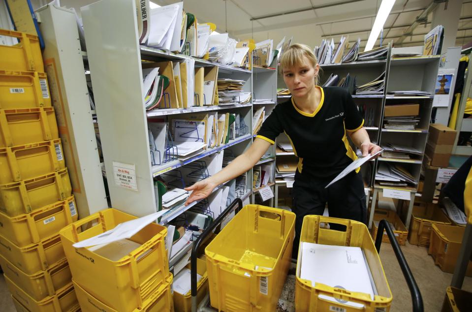 Sabine Standke, 32-year-old postwoman of the German postal and logistics group Deutsche Post, sorts mail at a sorting office in Berlin's Mitte district, December 4, 2013. Deutsche Post, the world's number one postal and logistics group transported around 18 billion letters in 2012. REUTERS/Fabrizio Bensch (GERMANY - Tags: BUSINESS EMPLOYMENT)