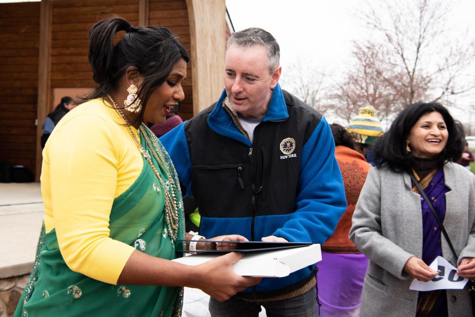 Silvi Haldipur, Desis of Doylestown president, is presented with a U.S. flag from Congressman Brian Fitzpatrick before the start of the Saree Run held at Central Park in Doylestown Township, on Sunday, March 27, 2022.