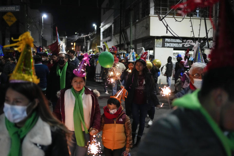 Residents participate in the procession of "Ninopan" during a Christmas "posada," which means lodging or shelter, in the Xochimilco borough of Mexico City, Wednesday, Dec. 21, 2022. For the past 400 years, residents have held posadas between Dec. 16 and 24, when they take statues of baby Jesus in procession to church for Mass to commemorate Mary and Joseph's cold and difficult journey from Nazareth to Bethlehem in search of shelter. (AP Photo/Eduardo Verdugo)