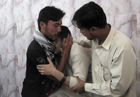 Men mourn the death of a relative, who was killed with two others by unidentified gunmen, in a hospital Quetta, Pakistan, July 6, 2015. REUTERS/Naseer Ahmed