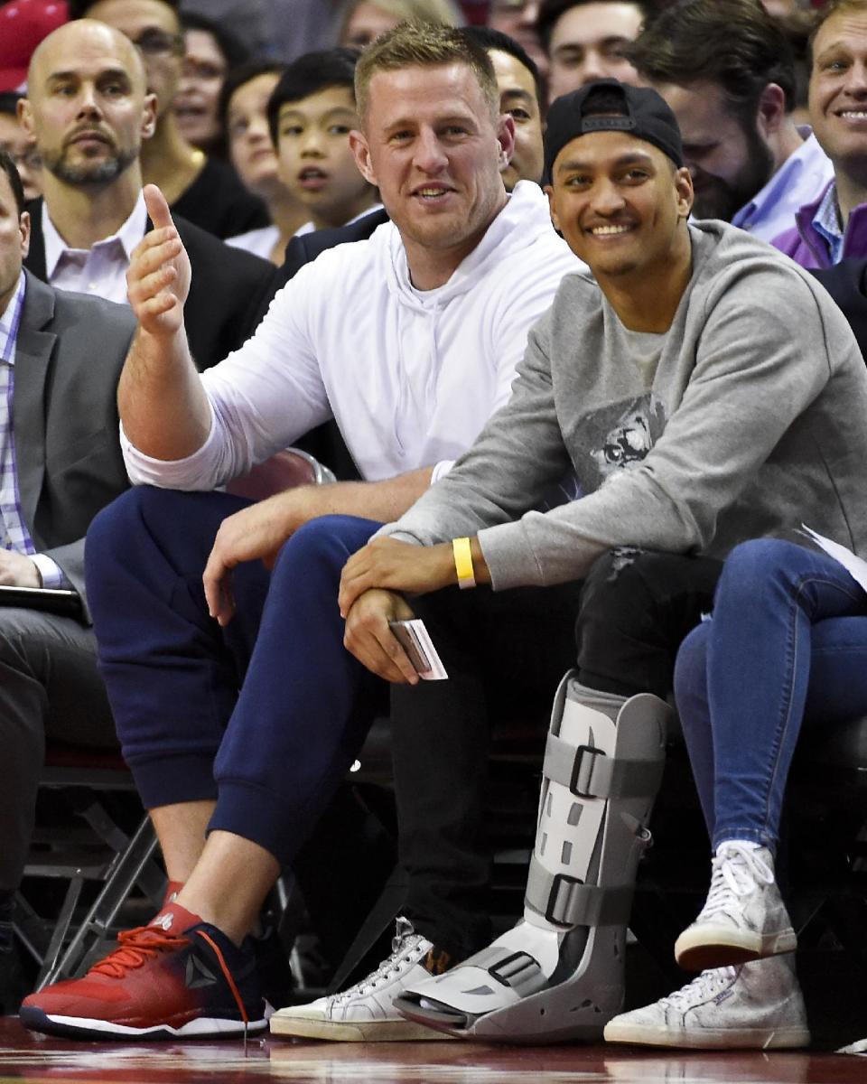 Houston Texans defensive end JJ Watt, left, and defensive back Kevin Johnson watch an NBA basketball game between the Houston Rockets and the Golden State Warriors on Friday, Jan. 20, 2017, in Houston. (AP Photo/Eric Christian Smith)