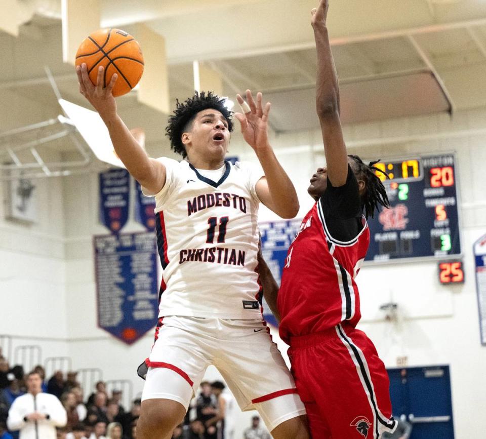 Modesto Christian’s Gavin Sykes scores over Lincoln’s Anthony Moore during the Tri-City Athletic League game at Modesto Christian High School in Salida, Calif., Friday, Jan. 12, 2024. Modesto Christian won the game 68-53. Andy Alfaro/aalfaro@modbee.com