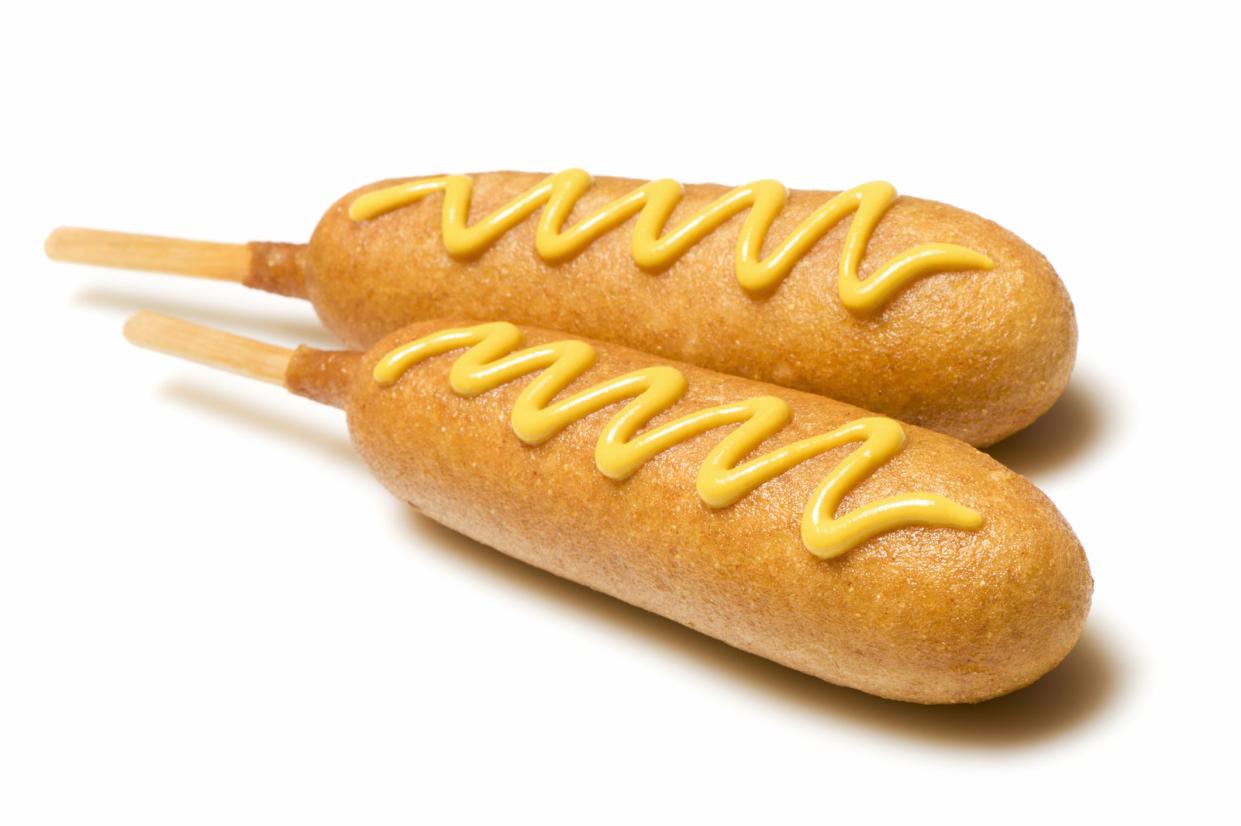 Two corn dogs with mustard isolated on white. More pictures in lightbox...