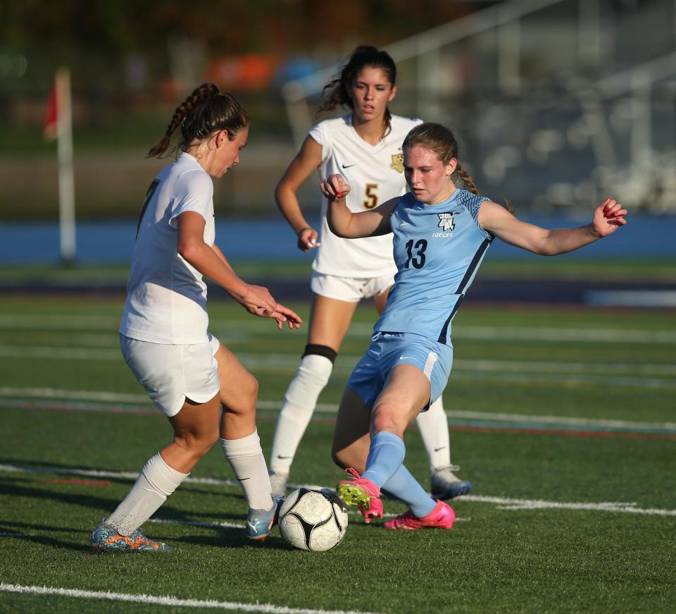 John Jay's Kaleigh Horos looks to maneuver between two Arlington defenders during an Oct. 4, 2023 girls soccer game.