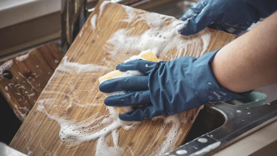 A woman washing a cutting board