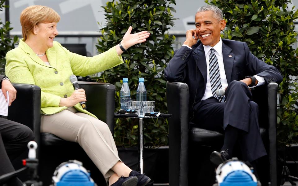 Angela Merkel and Barack Obama attend a discussion at the German Protestant Kirchentag in front of the Brandenburg Gate in Berlin - Credit: AXEL SCHMIDT/ REUTERS