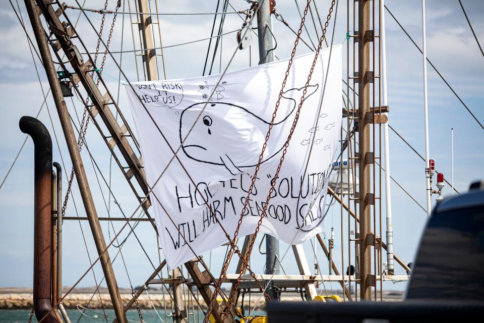 A poster in the rigging on a ship at the wharf during the rally against Holtec releasing wastewater into Cape Cod Bay in Plymouth on Saturday, April 9, 2022.
