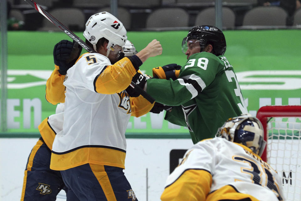 Nashville Predators defenseman Matt Benning (5) takes a punch from Dallas Stars center Joel L'Esperance (38) during a fight in the second period of an NHL hockey game on Sunday, March 7, 2021, in Dallas. (AP Photo/Richard W. Rodriguez)