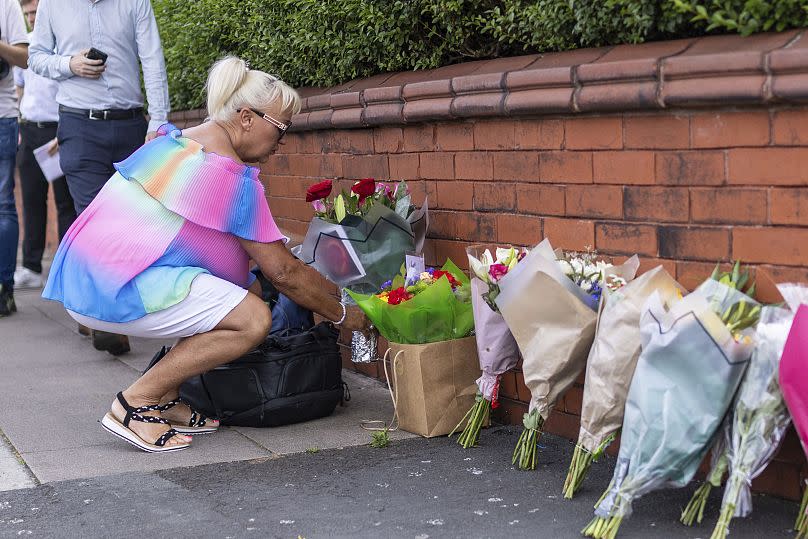 Una persona coloca flores cerca de la escena del ataque en Hart Street, Southport.