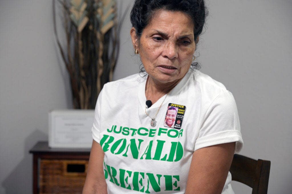 Mona Hardin relives the events surrounding the death of her son Ronald Greene as his boxed ashes sit behind her on a table, Saturday, Dec. 4, 2021, in Orlando, Fla. (AP Photo/Phelan M. Ebenhack)