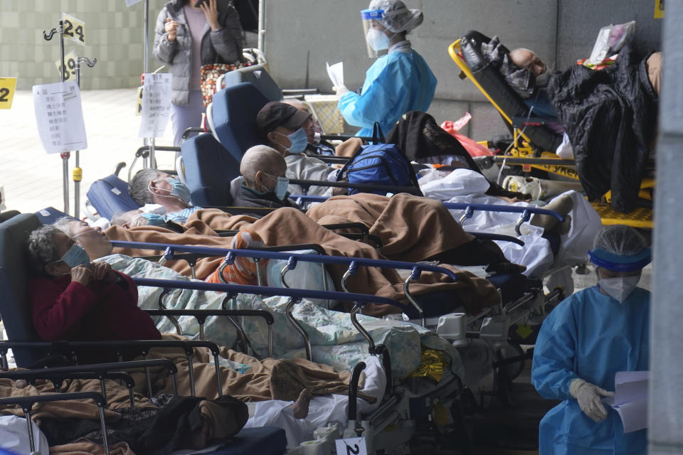 Patients on hospital beds wait at temporary holding area outside Caritas Medical Centre in Hong Kong, Monday, Feb. 28, 2022. (AP Photo/Vincent Yu)