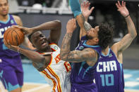 Atlanta Hawks center Clint Capela (15) looks to pass as he drives into Charlotte Hornets forward Miles Bridges during the first half of an NBA basketball game in Charlotte, N.C., Sunday, April 11, 2021. (AP Photo/Nell Redmond)