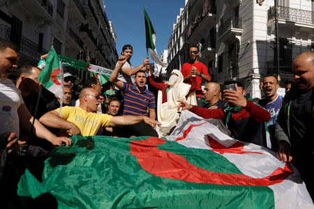 People carry their national flags as they protest over President Abdelaziz Bouteflika's decision to postpone elections and extend his fourth term in office, in Algiers, Algeria March 15, 2019. REUTERS/Zohra Bensemra