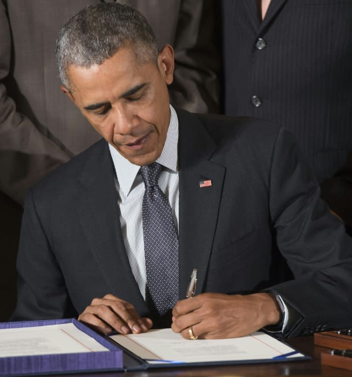US President Barack Obama signs a bill which includes fast track trade authority that allows him to negotiate trade treaties, including the Trans-Pacific Partnership, in Washington, DC, June 29, 2015