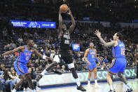 San Antonio Spurs guard Sidy Cissoko (25) grabs a rebound before Oklahoma City Thunder center Bismack Biyombo (15) and forward Lindy Waters III (12) in the second half of an NBA basketball game, Wednesday, April 10, 2024, in Oklahoma City. (AP Photo/Kyle Phillips)