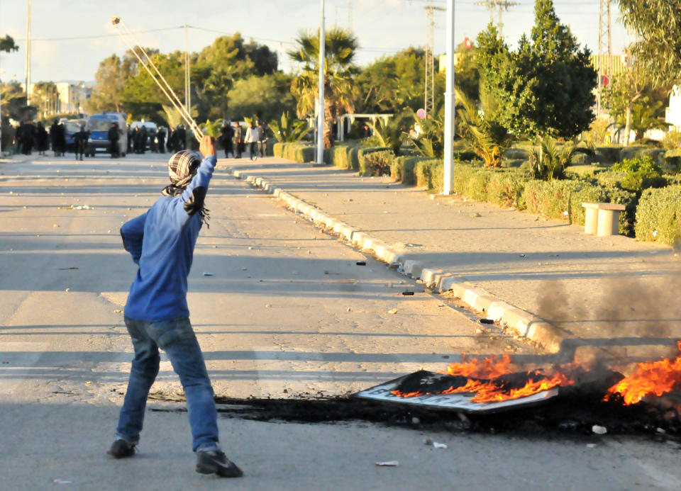 A demonstrator uses a slingshot against government forces in Siliana, northern Tunisia, Thursday, Nov.29, 2012. Tunisia's army intervened in a third day of violent clashes in a northern town between police and striking residents who are demanding jobs and investment. After two days of battles that a hospital said left more than 300 people injured, police pulled out of Siliana Wednesday night. Witnesses said 15,000 people marched through the town Thursday demanding the governor's resignation. (AP Photo)