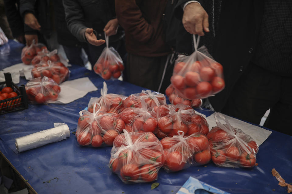 In this Sunday, Feb. 17, 2019 photo, shoppers wait in line to buy tomatoes at a government-run market selling spinach, tomatoes and peppers at discounted prices in an Istanbul neighbourhood. Turkey's President Recep Tayyip Erdogan's government has set up dozens of these temporary stalls in Turkey's largest cities in a bid to mitigate the effects of soaring food prices that have stung households. The move comes just over a month before Erdogan faces local elections on March 31, when runaway prices and an economic downturn could cost his ruling party some key municipal seats. (AP Photo/Emrah Gurel)