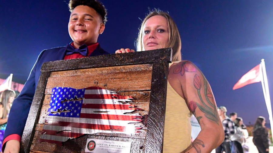 Shana Chappell, right, mother of Marine Lance Cpl. Kareem Nikoui, holds a plaque honoring her fallen son following a vigil on the eve of the first anniversay for the 13 U.S. Marines killed in an attack at the Kabul International Airport Lancei at George A. Ingalls Memorial Plaza in Norco on Thursday Aug. 25, 2022.