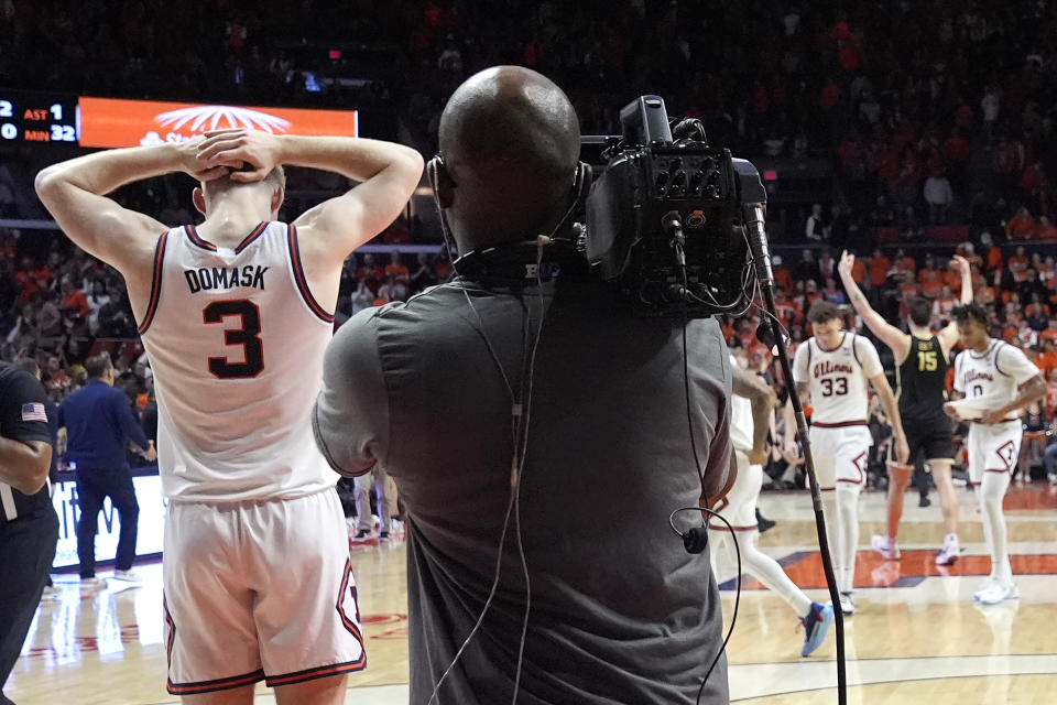 Illinois's Marcus Domask (3) reacts to the team's 77-71 loss to Purdue as teammates Coleman Hawkins and Terrence Shannon Jr. head to the locker room and Purdue's Zach Edey (15) celebrates after an NCAA college basketball game Tuesday, March 5, 2024, in Champaign, Ill. (AP Photo/Charles Rex Arbogast)