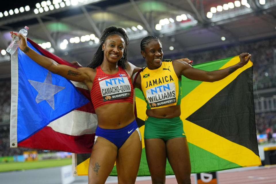 Danielle Williams, of Jamaica celebrates with silver medalistJasmine Camacho-Quinn, of Puerto Rico, after winning the gold medal in the final of the Women's 100-meters hurdles during the World Athletics Championships in Budapest, Hungary, Thursday, Aug. 24, 2023. (AP Photo/Petr David Josek)