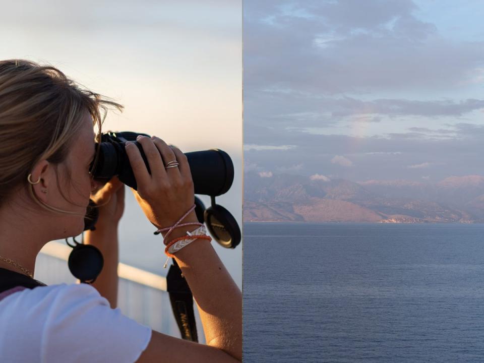 Freelancer Kristina Murkett using binoculars to see mountains.