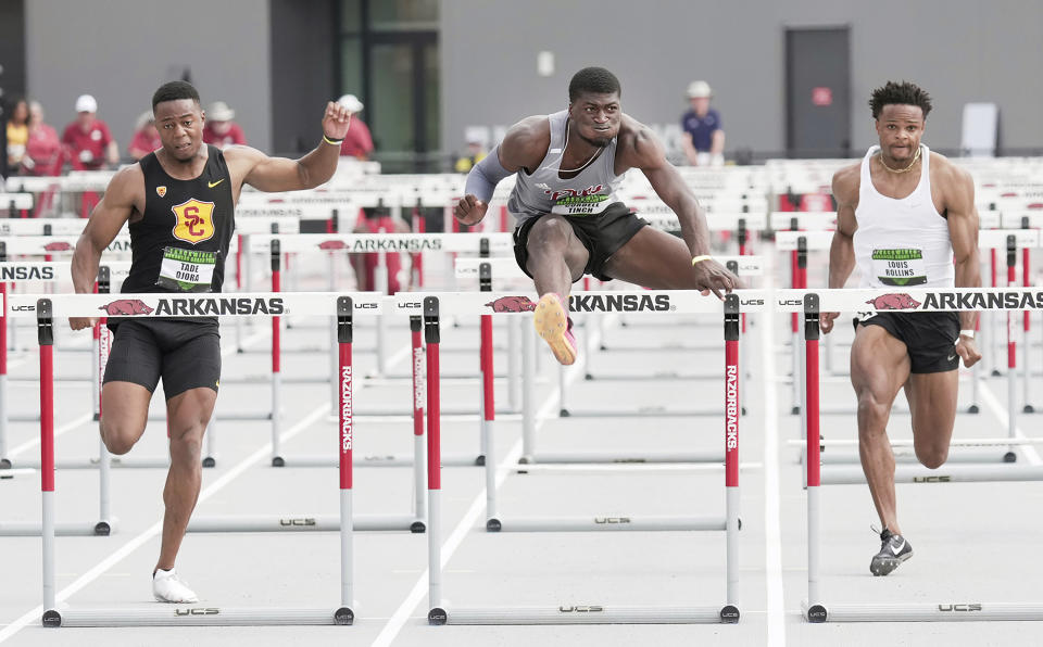 This photo provided by Pittsburg State Athletics shows Pittsburg State hurdler Cordell Tinch, center, competing against British hurdler Tade Ojora of USC, left, and Louis Rollins, unattached, in the 110m hurdles final at the Arkansas Grand Prix athletics event in Fayetteville, Ark., June 23, 2023. Just seven months ago, the hurdler with the world's fastest time this season wasn't even a hurdler at all. Cordell Tinch was selling the latest versions of cell phones and watches at a store in Green Bay, Wisconsin. (Shawn Price/Pittsburg State via AP)