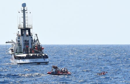 Migrants jump off the Spanish rescue ship Open Arms, close to the Italian shore in Lampedusa