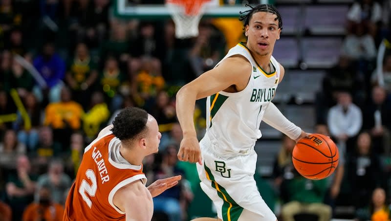 Baylor's Miro Little, right, dribbles past Texas's Chendall Weaver (2) during the first half of an NCAA college basketball game, Monday, March 4, 2024, in Waco, Texas. Little announced he is transferring to Utah.