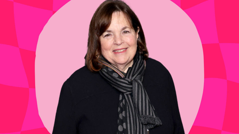 Ina Garten wearing a black top and scarf on a pink background