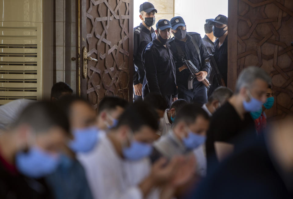 Palestinian Hamas police stand guard at the entrance of a mosque as worshipers attend the last Friday noon Prayer of the holy month of Ramadan, in Gaza City, Friday, May. 22, 2020. After nearly two months of closure due to the coronavirus, Gaza's Hamas rulers decided to partially reopen mosques for the Friday noon prayer. (AP Photo/Khalil Hamra)