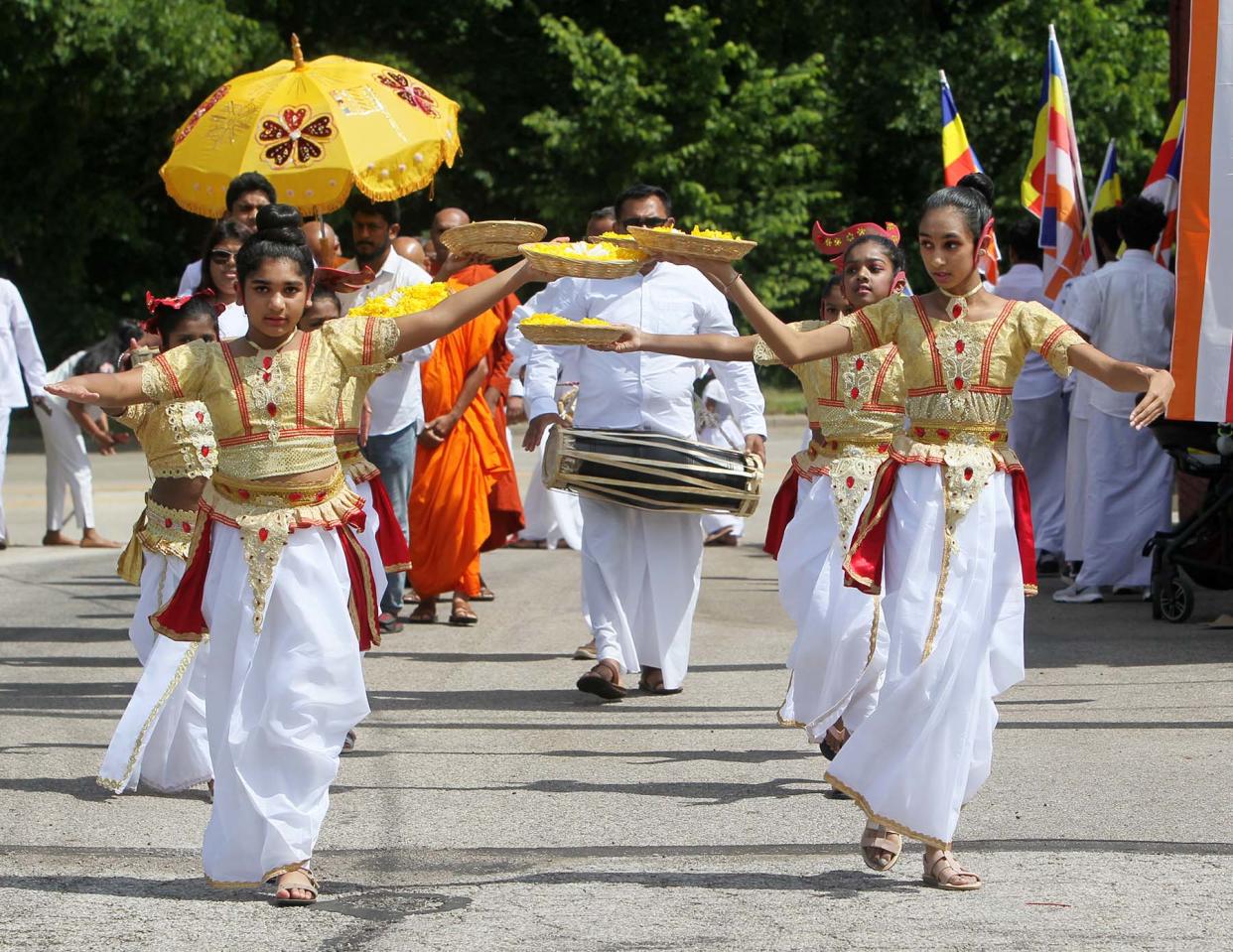Dancers in traditional costumes lead the Procession of Maha Sangha to the dedication ceremony for the Cleveland Buddhist Vihara and Meditation Center in Akron on Saturday.