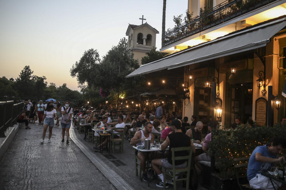 People sit at a restaurant in the Plaka district of Athens on Friday July 16, 2021. Greece became the latest on Friday, with a new measure coming into effect requiring proof of vaccination or recent recovery from COVID-19 for access to indoor restaurants, cafes, bars and movie theaters. Children can enter with negative tests. (AP Photo/Petros Giannakouris)