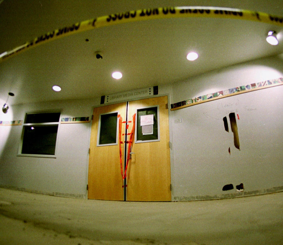 FILE - In this June 15, 1999, file photo, tape marks the line in front of the doors to the library in Columbine High School as members of the media took their first trip through the school in the southwest Denver suburb of Littleton, Colo. Twelve students and one teacher were killed in a murderous rampage at the school on April 20, 1999, by two students who killed themselves in the aftermath. (AP Photo/David Zalubowski, File)