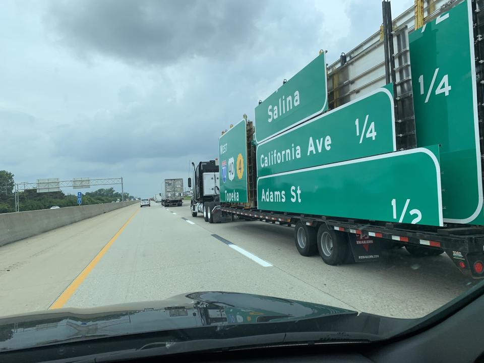 Highway signs traveling down a highway on a truck