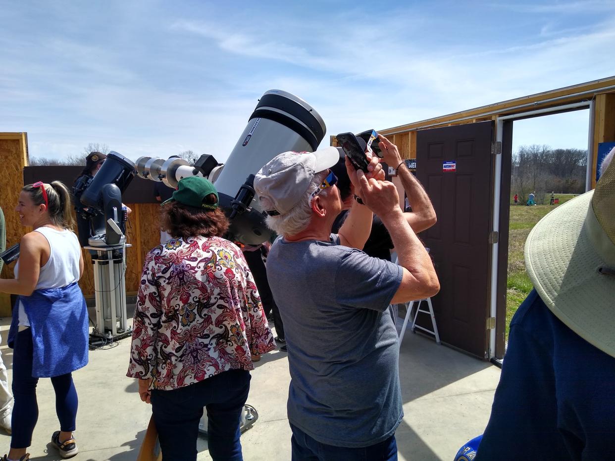Visitors look through special viewers and telescopes at the Fairlawn Rotary Observatory at Bath Nature Preserve as the total solar eclipse begins Monday in Bath Township. The Summit County Astronomy Club held a watch party at the observatory.