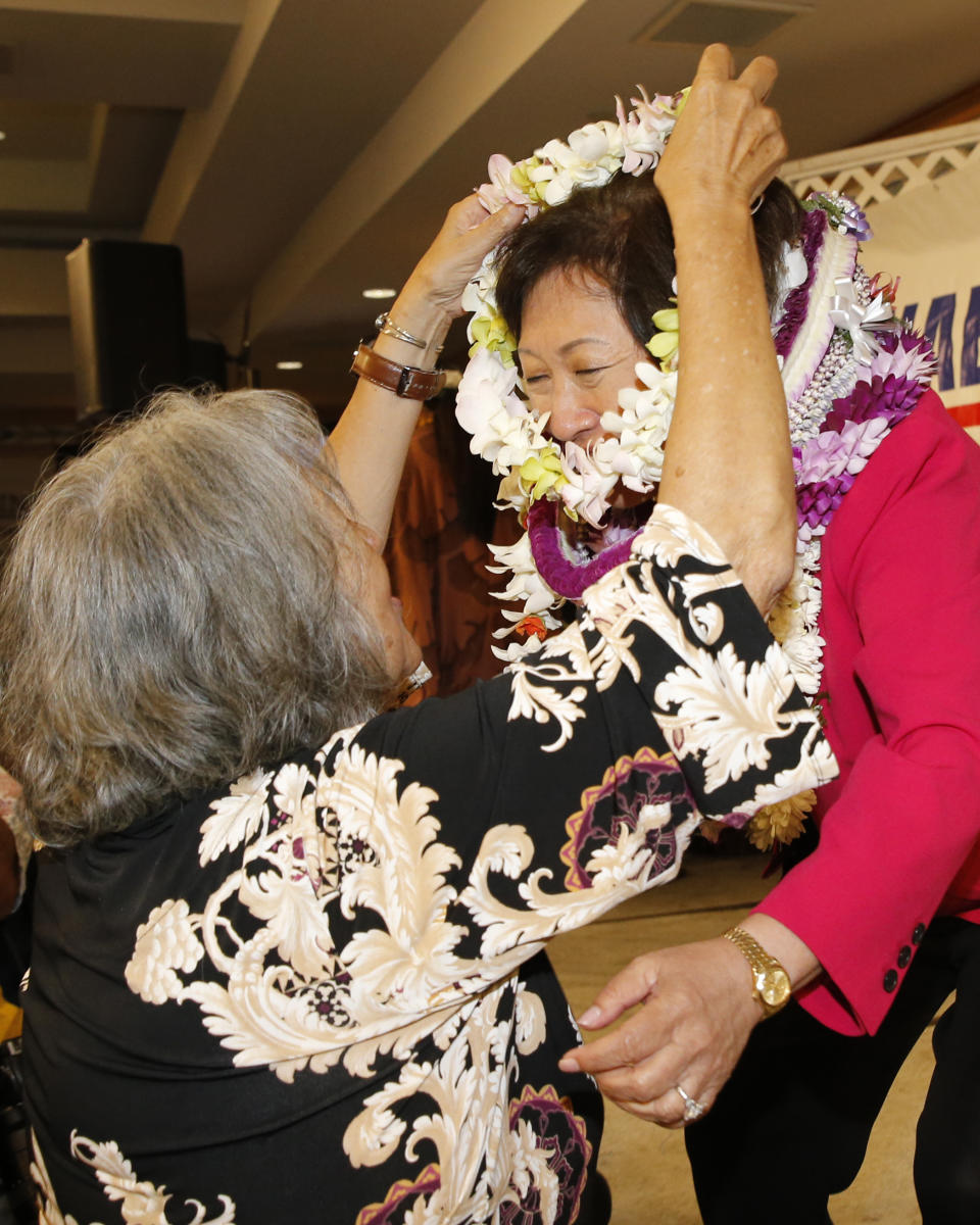 U.S. Rep Colleen Hanabusa receives a Hawaiian lei from a supporter at her campaign headquarters, Saturday, Aug. 11, 2018, in Honolulu. (AP Photo/Marco Garcia)