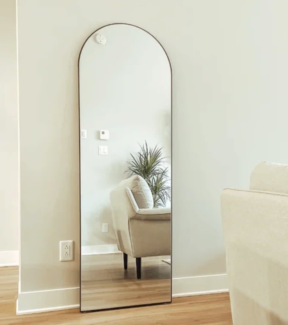 A reviewer's floor length mirror against a wall in a living room
