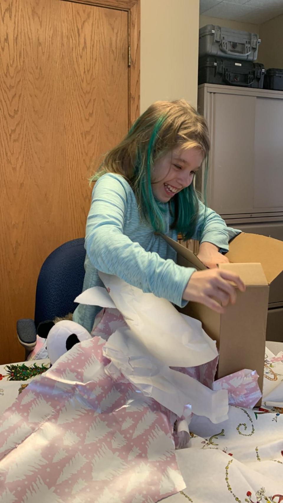 Nine-year-old Summer Lahaie unwraps a gift on Wednesday, Nov. 30.