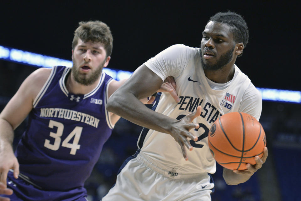 Northwestern's Matthew Nicholson (34) attempts to knock the ball away from Penn State's Qudus Wahab (22) during the first half of an NCAA college basketball game Wednesday, Jan. 10, 2024, in State College, Pa. (AP Photo/Gary M. Baranec)