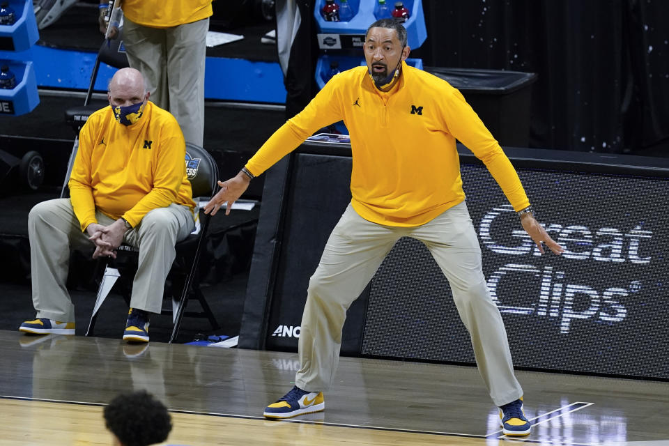 Michigan head coach Juwan Howard reacts to a play as assistant coach Phil Martelli looks on from the bench during the first half of an Elite 8 game against UCLA in the NCAA men's college basketball tournament at Lucas Oil Stadium, Tuesday, March 30, 2021, in Indianapolis. (AP Photo/Darron Cummings)