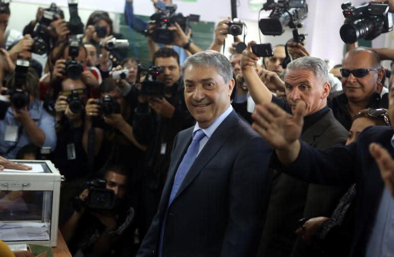 Ali Benflis (C), Algerian opposition leader and main rival to President Abdelaziz Bouteflika, arrives at a polling station to cast his vote in Algiers on April 17, 2014