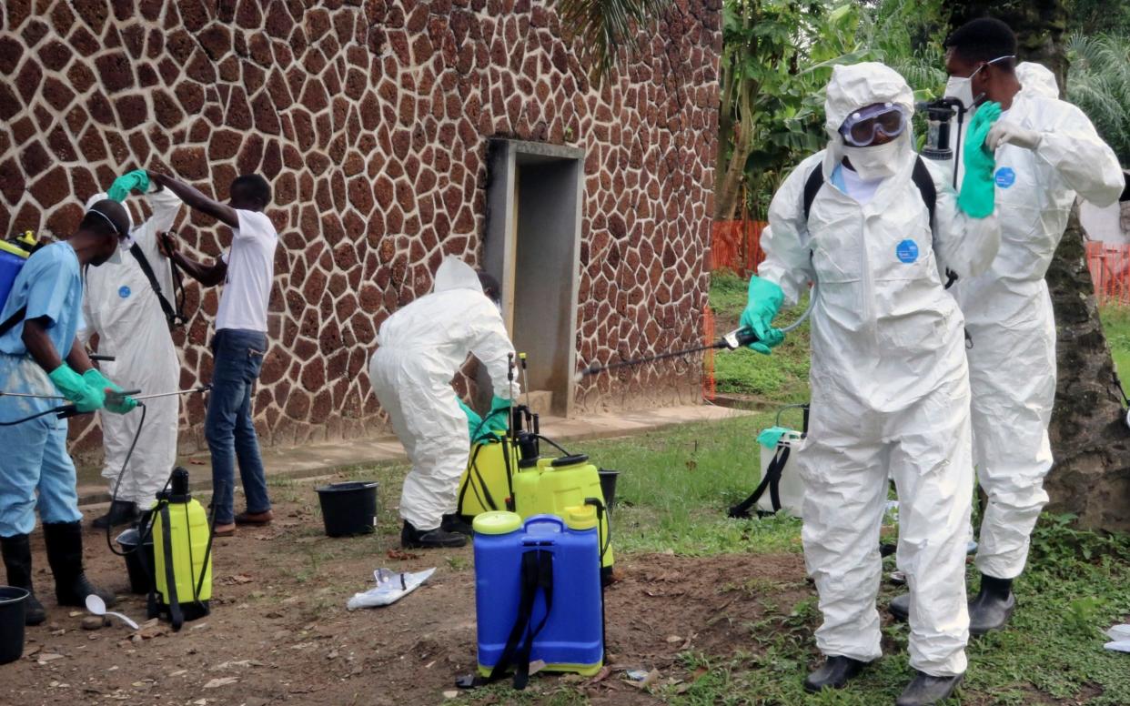 Congolese health officials disinfect people and buildings at a hospital in Mbandaka, Congo during the country's previous outbreak.  - AP