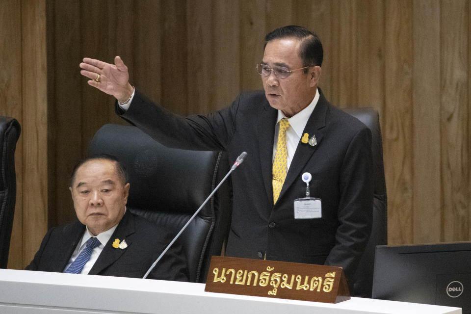 Thailand Deputy Prime Minister Prawit Wongsuwan, left, listens as Thailand's Prime Minister Prayuth Chan-ocha answers a question at parliament in Bangkok, Thailand, Wednesday, Sept. 18, 2019. Prayuth has come under fire in a parliamentary debate because he omitted a key phrase in taking his oath of office in July, but dodged opposition demands to explain why he had left it out. (AP Photo/Sakchai Lalit)
