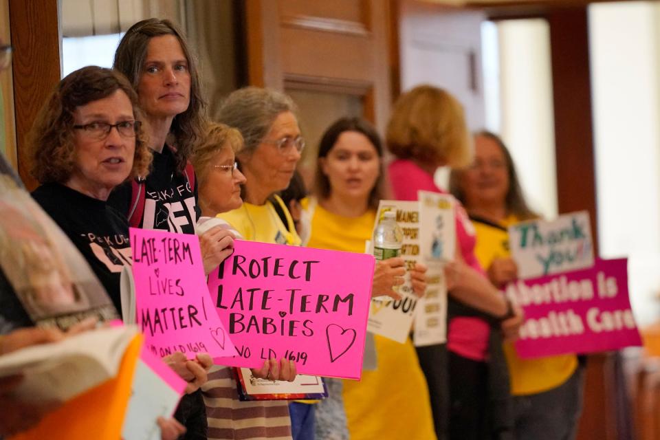 Protesters line the hallway leading to the House Chamber, Wednesday, June 21, 2023, at the State House in August, Maine. The Legislature is working to wrap up the current session before summer break.