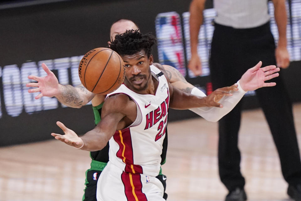 Miami Heat's Jimmy Butler (22) reaches for the ball during the second half of an NBA conference final playoff basketball game against the Boston Celtics Friday, Sept. 25, 2020, in Lake Buena Vista, Fla. The Celtics won 121-108. (AP Photo/Mark J. Terrill)