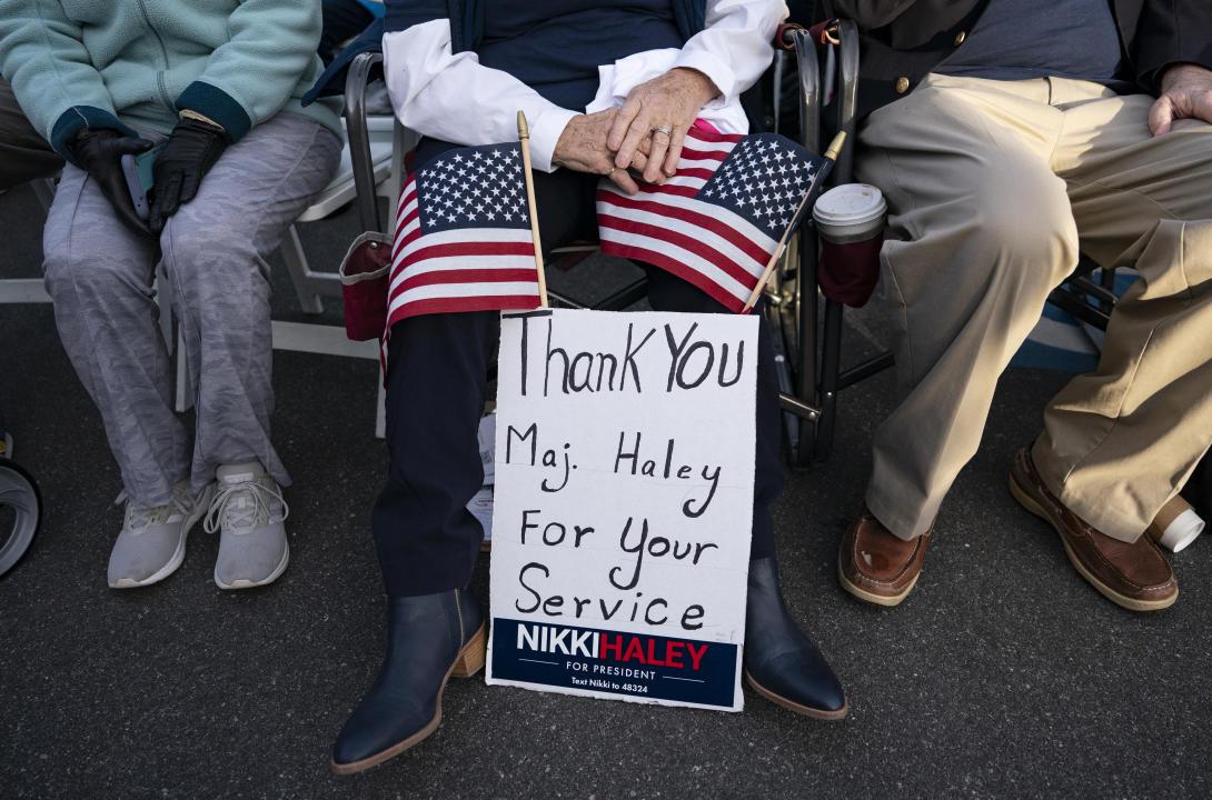 A Nikki Haley supporter holds a sign thanking her husband for his service.