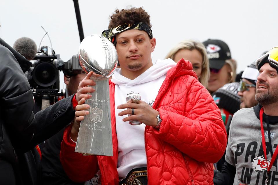 Kansas City Chiefs quarterback Patrick Mahomes holds on to the Vince Lombardi Trophy as he rides in a victory parade through downtown Kansas City